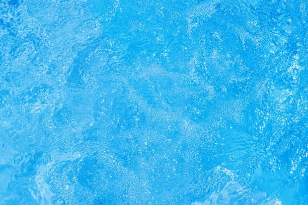 Serene blue water surface with gentle ripples and a soft sun glow