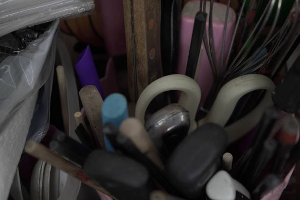 A chaotic yet charming still life of kitchen utensils. The jumble of tools and gadgets creates a sense of energy and activity. This photograph captures the heart of a busy kitchen