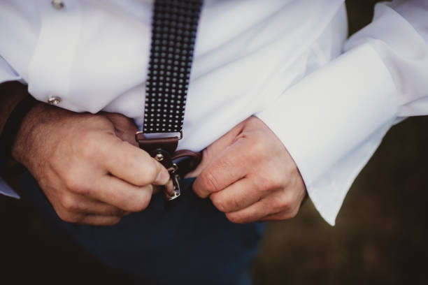 Businessman getting formally dressed in suit with suspenders