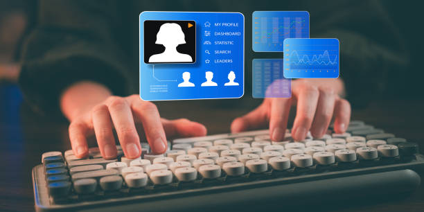 istock Hands typing on a keyboard with a futuristic digital human resource interface, showing user profiles, analytics, and employee statistics 2192461284