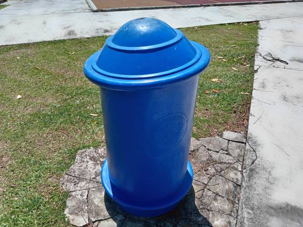 istock Blue plastic trash can in the park.  Cleaning service concept. 2192462198