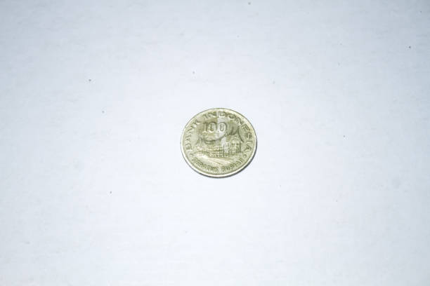 Photo of coins from Indonesia worth one hundred rupiah. Made in 1978. The coin contains images of mountains of puppet and traditional houses from Indonesia.