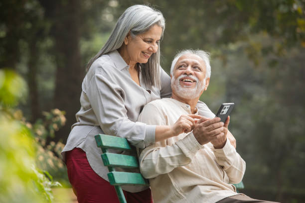 istock Senior couple using phone in park 2192463729