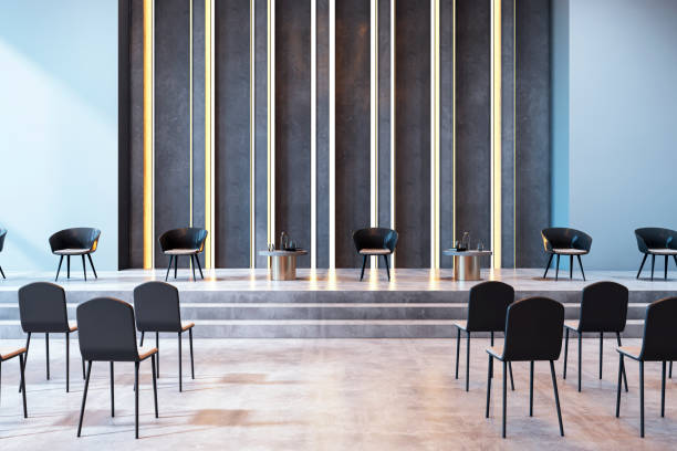 istock Modern conference hall interior with empty chairs and stage with stylish decor and lighting. 3D Rendering 2192466359