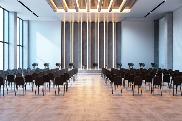 Modern spacious conference hall interior with rows of chairs and stage, featuring stylish design and ample natural light. 3D Rendering