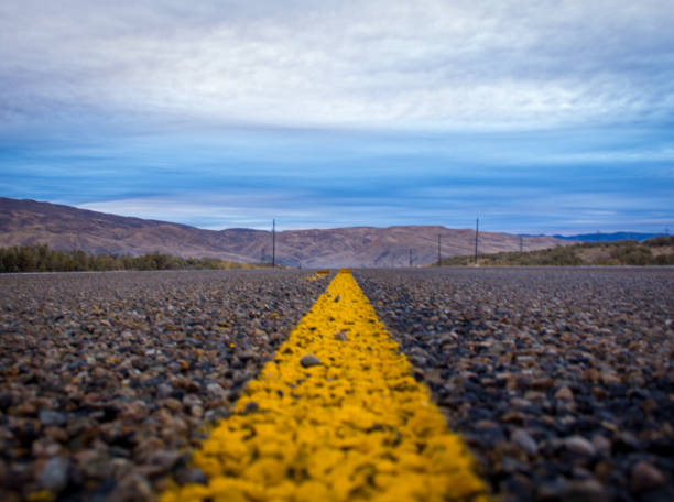 istock Highway Lines Leading to Mountains 2192468018