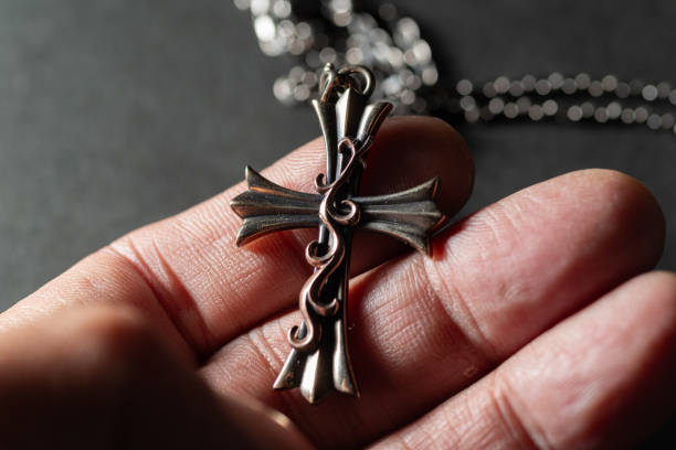 istock A cool cross pendant in his hand 2192475039