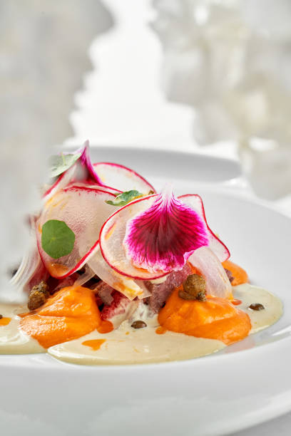 istock A gourmet dish featuring a delicate piece of venison steak, surrounded by a vibrant arrangement of fresh vegetables and edible flowers 2192477954