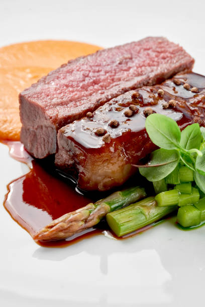 istock A gourmet dish featuring a perfectly cooked steak, served with a side of creamy mashed potatoes and a vibrant green vegetable. 2192478662