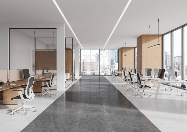 istock Modern office interior with large windows and desks in an open layout, city view from background. 3D Rendering 2192479402