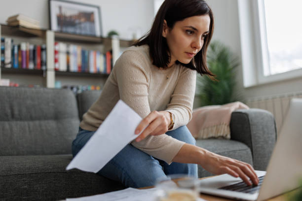 istock Woman reviewing financial documents while working on her laptop at home 2192481576
