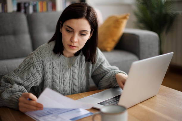 istock Young woman analyzing bills and expenses at home 2192481668