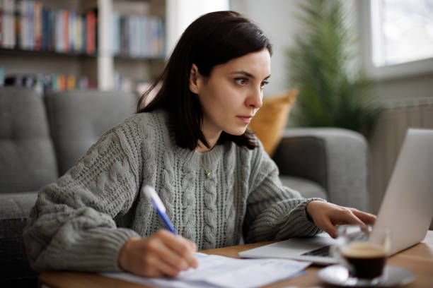 istock Woman reviewing financial documents at home 2192481699