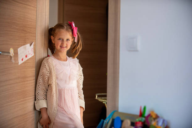 istock Young girl smiling while standing next to a door at home 2192483555