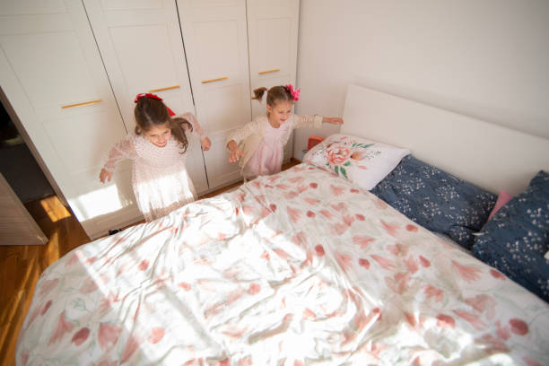 istock Children having fun jumping on a cozy bed in a bright bedroom 2192484316