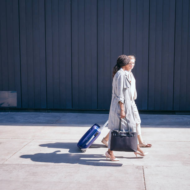 istock Two Women Walking with Luggage. 2192484943