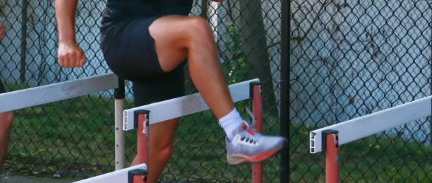 istock Man Training by Jumping Over Hurdles in an Outdoor Athletic Facility During Daylight Hours 2192487676