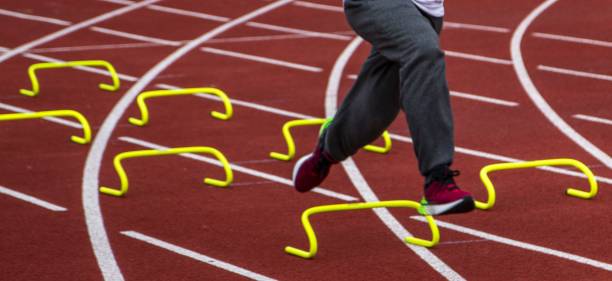 istock Runner Practices Agility Drills at Track With Hurdles on a Sunny Day 2192487710