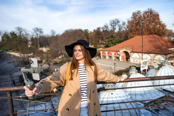 Stylish young woman documenting her travels with a smartphone in hand