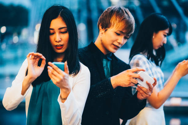 istock Japanese students in Osaka street texting on smartphone 2192491640