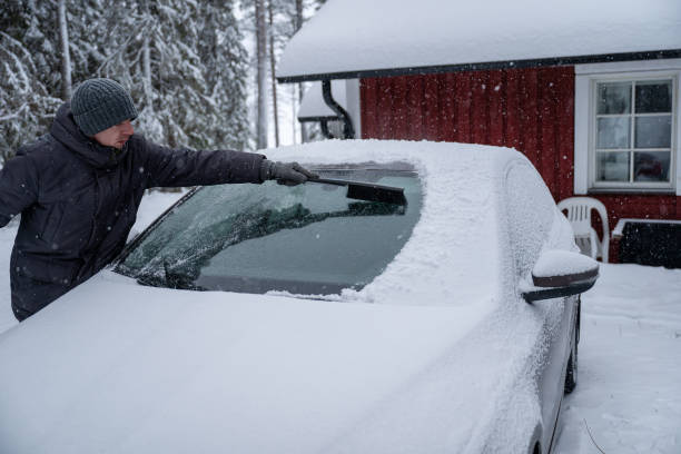 istock man remove her car from snow with brush. Car wash concept. 2192492052