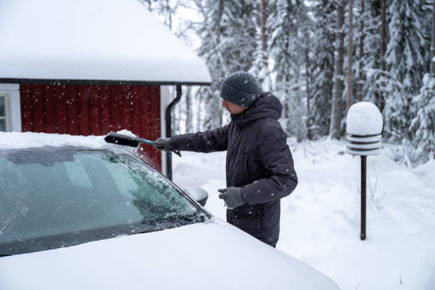 istock man remove her car from snow with brush. Car wash concept. 2192492069