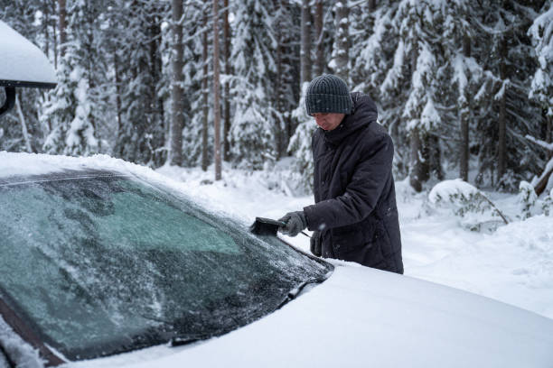istock man remove her car from snow with brush. Car wash concept. 2192492708