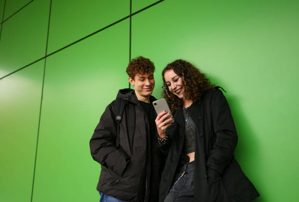 istock Two young friends deeply engaged with their phones 2192494213