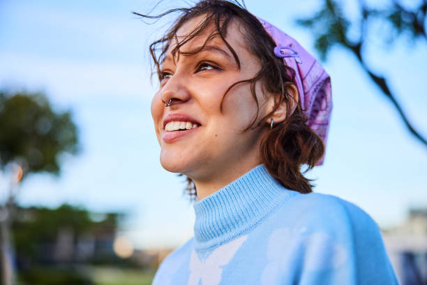 Portrait of cheerful young woman wearing headscarf, looking away stock photo