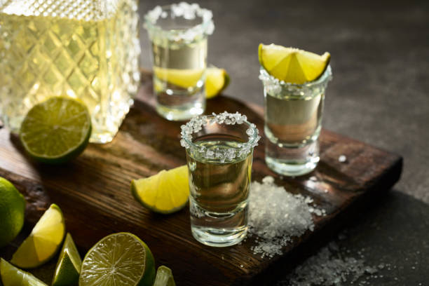 istock Tequila with sea salt and lime slices on a old cutting board. 2192501779