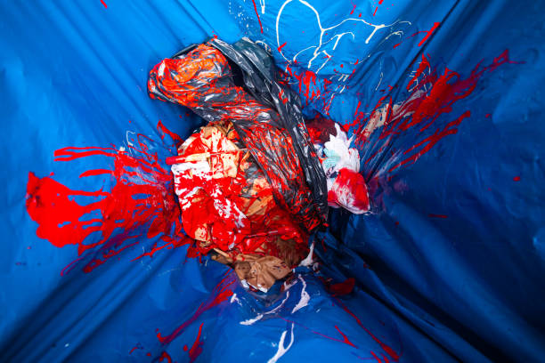 istock Dirty rags in a trash bag stained with red paint. 2192502089