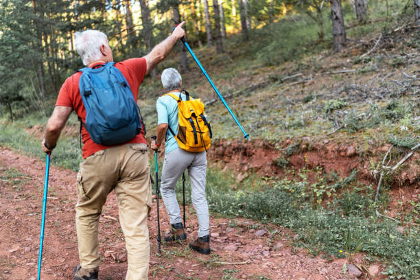 istock Active senior couple with backpacks hiking together in nature 2192504323
