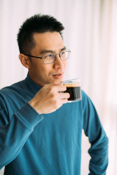 istock Happy Asian man drinking coffee indoor 2192508358