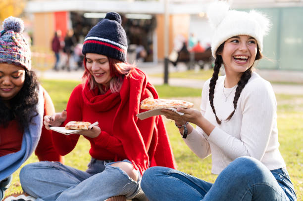 istock Friends sharing pizza sitting in a city park 2192509274