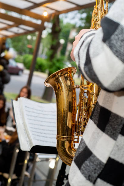 Saxophonist plays against the backdrop of the summer terrace of a restaurant