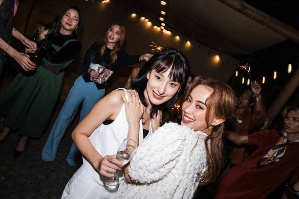 istock Joyful wedding celebration with two brides sharing a heartfelt moment surrounded by sparklers, friends, and vibrant energy in a memorable nightlife setting. 2192511443