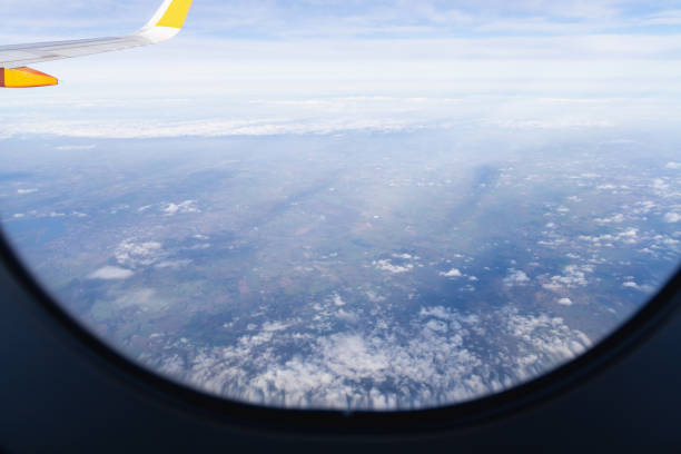 airplane wing against blue sky and white clouds