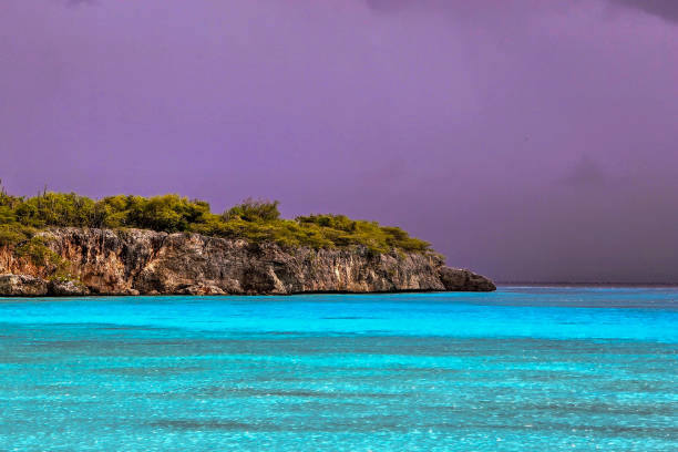 Coastline of the island of Curaçao, with blue sea against the dark sky of incoming storms.