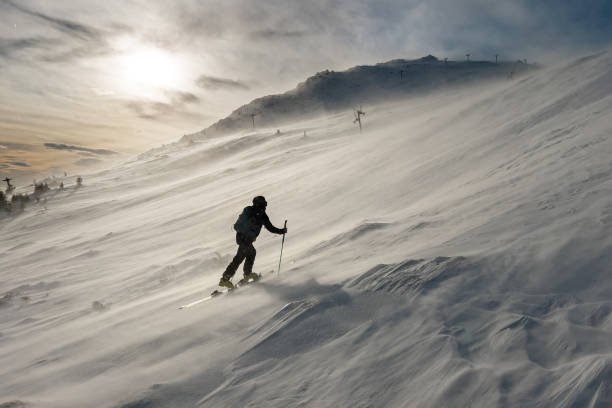 istock Back country skier battling winds on a snowy mountain slope 2192516730