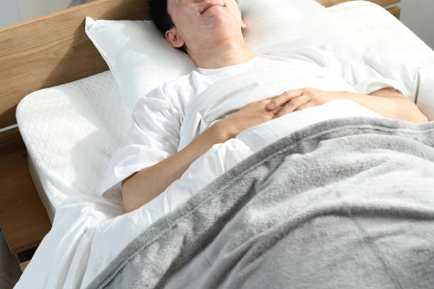 ベッドで快適に眠るアジアの若者 - おやすみ ストックフォトと画像