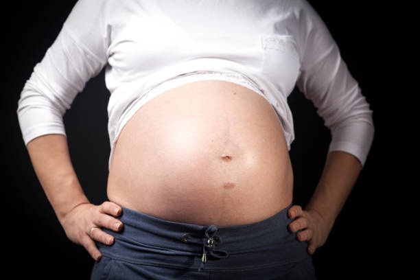 Pregnat woman hold her tummy close-up isolated on white background
