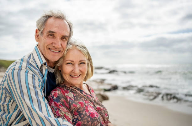 istock Elderly couple enjoying embrace on beach holiday 2192532217