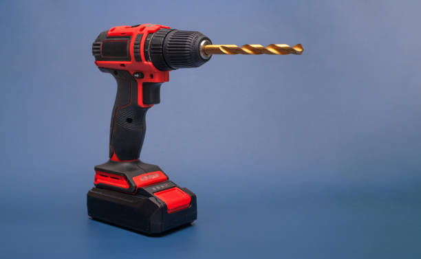 istock electric screwdriver with a cone drill on a blue background. 2192535059