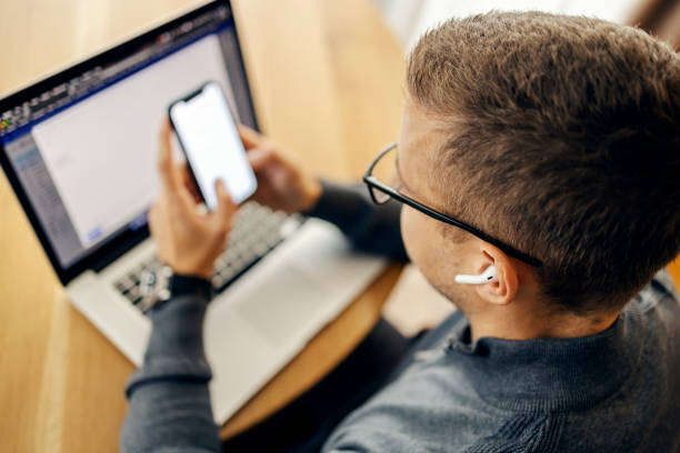 istock Close up of a man sitting at home with earbuds in ear and using cutting edge technologies. 2192535146