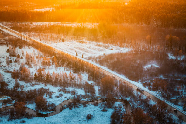 istock Snow Covered Landscape with Road, Stream, and Forest in Golden Light 2192535642