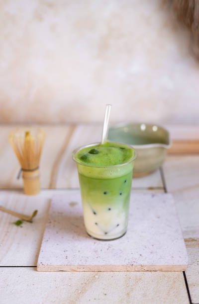 istock Green Tea Iced Matcha Latte prepared fresh on bright kitchen counter with milk, ice cubes and frothy matcha foam 2192535729