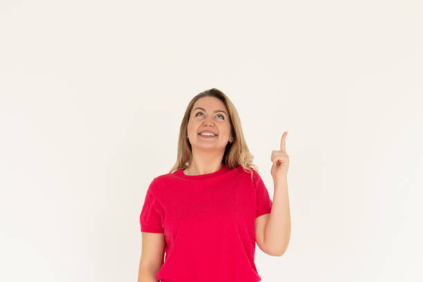 istock Smiling woman pointing finger up over white background 2192535867