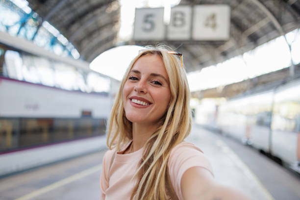 istock Smiling tourist taking selfie at train station 2192539150