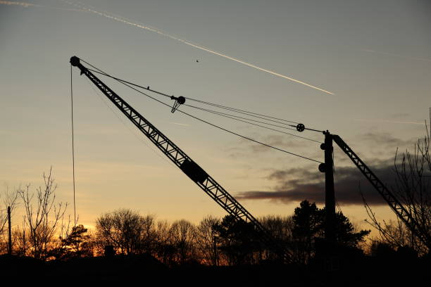 Silhouette of old crane against setting sun