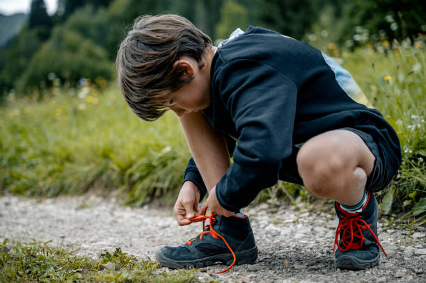 istock Child tying shoelaces outdoors 2192541089